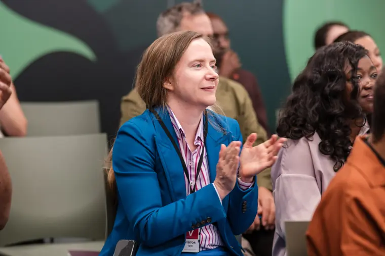 An attendee applauds a founder presentation.
