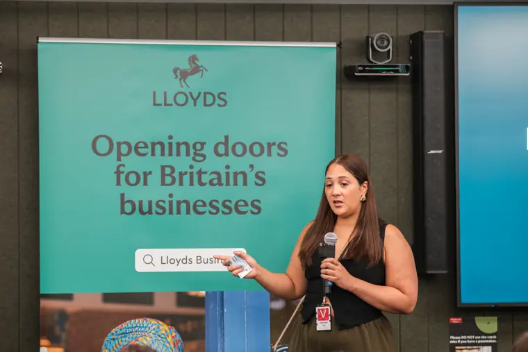 A founder presents beside the event branding.