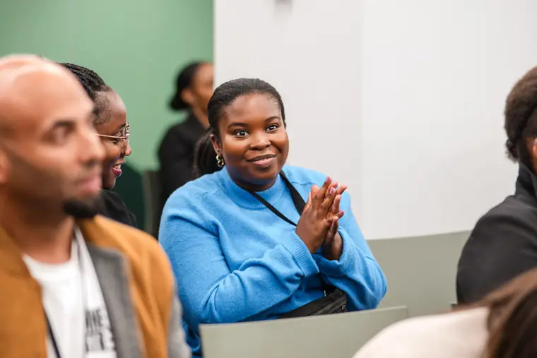 An attendee smiles during the applause.