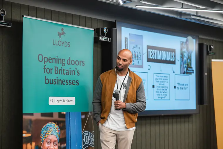 A founder pitches with his presentation on screen.