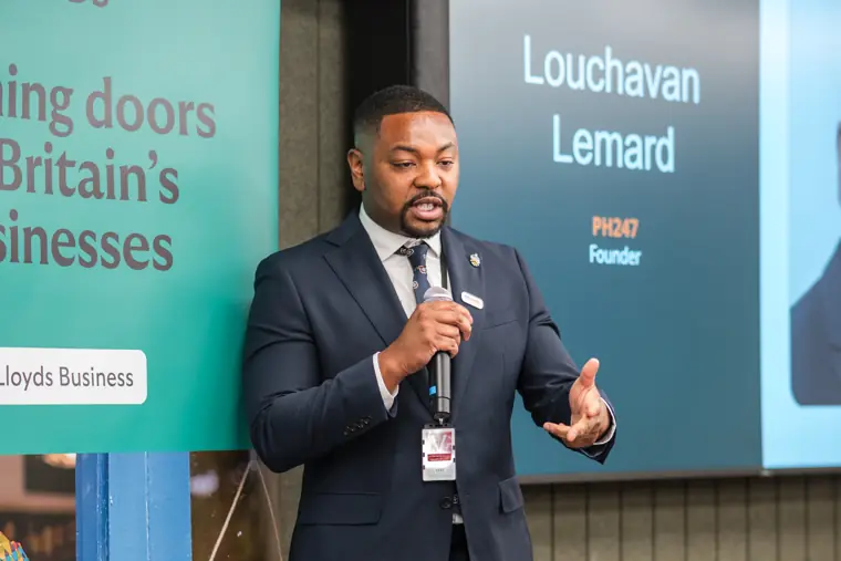 A founder speaks beside his presentation.