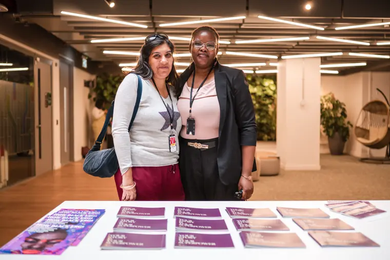 Two guests pose beside the welcome table.