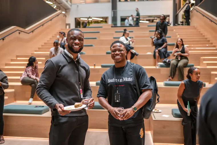 Two attendees pose for a portrait on the staircase.