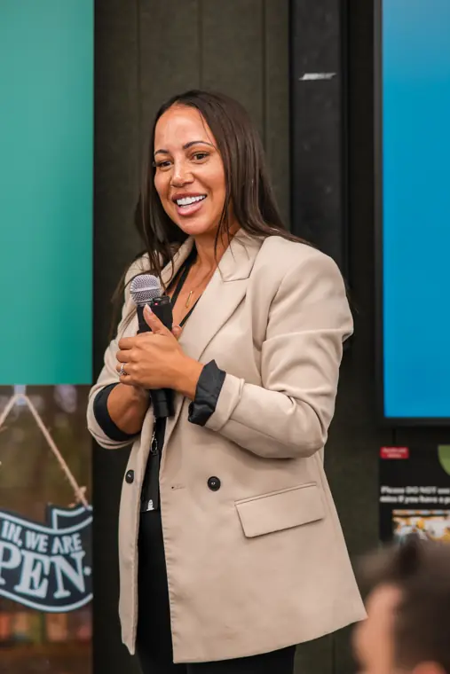 A speaker smiles as she addresses the room.