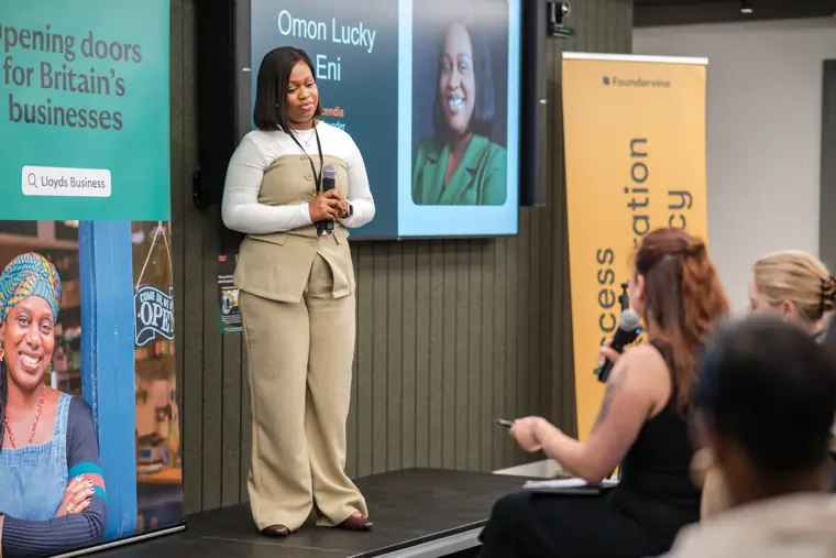 A founder speaks with the audience in view.