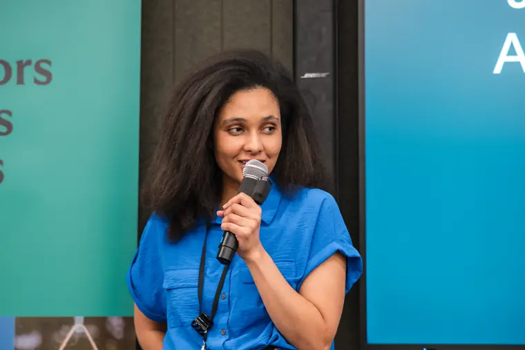 A founder speaks in front of the event backdrop.
