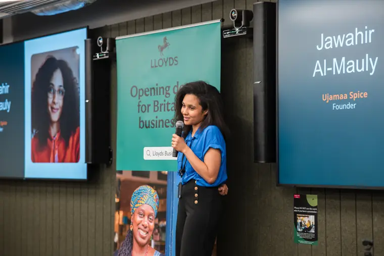 A founder pitches with her venture slide on screen.