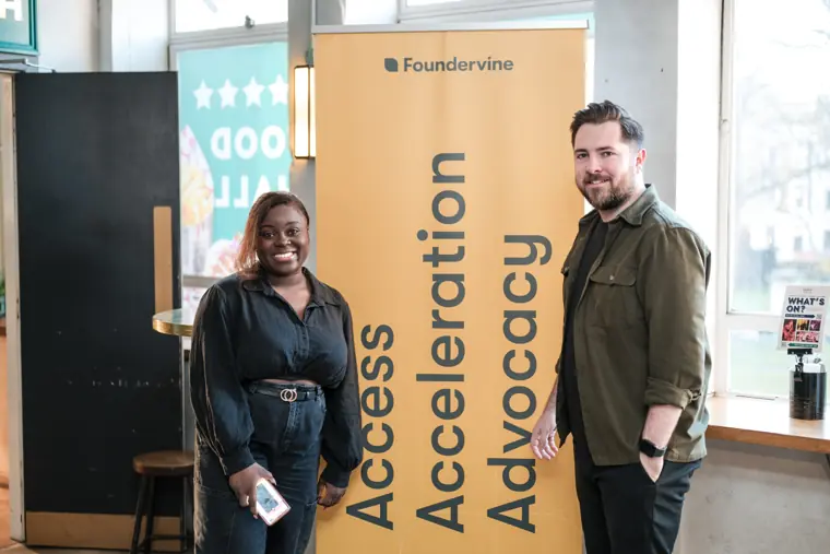 Two guests pose at the Foundervine display.