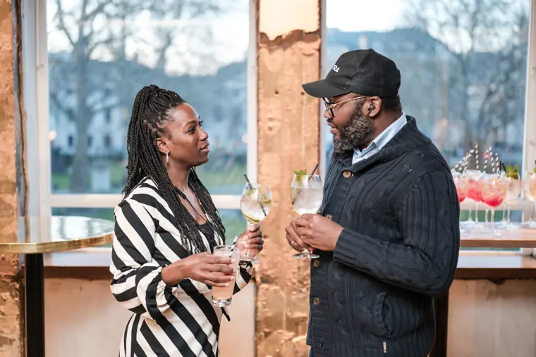 A founder talks with an attendee beside the window.
