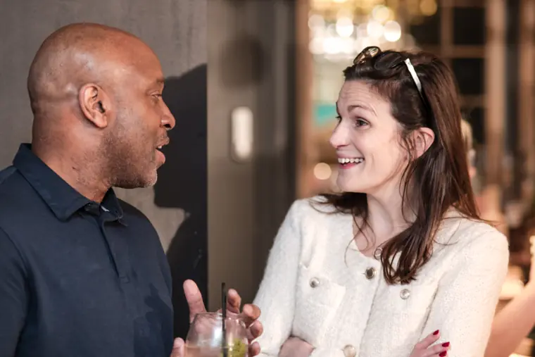 Two guests connect over a drink.