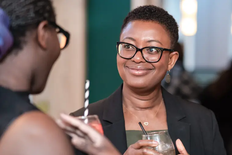 A guest smiles while talking with another attendee.