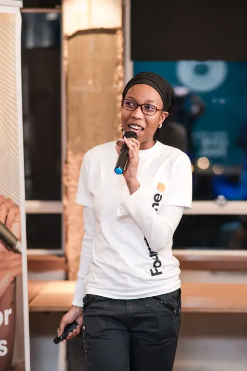 A founder speaks from the front of the room.