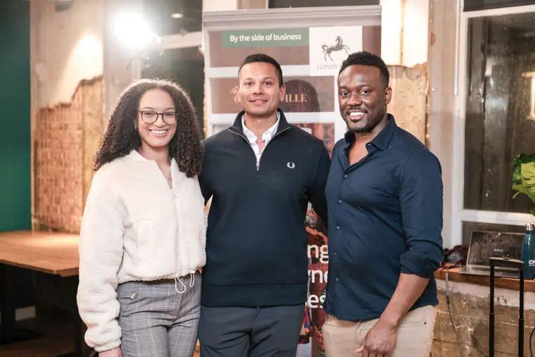 Three guests pose together at the venue.