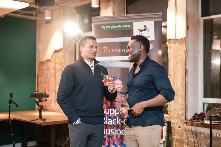Two guests talk beside the Foundervine display.