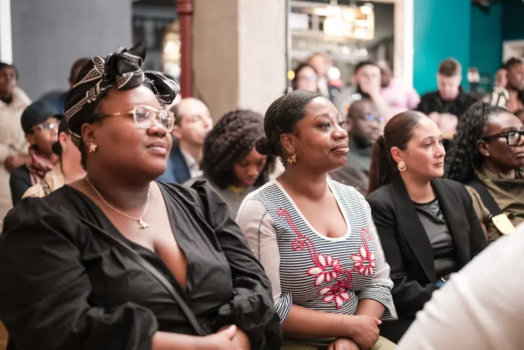 Audience members applaud a presentation.