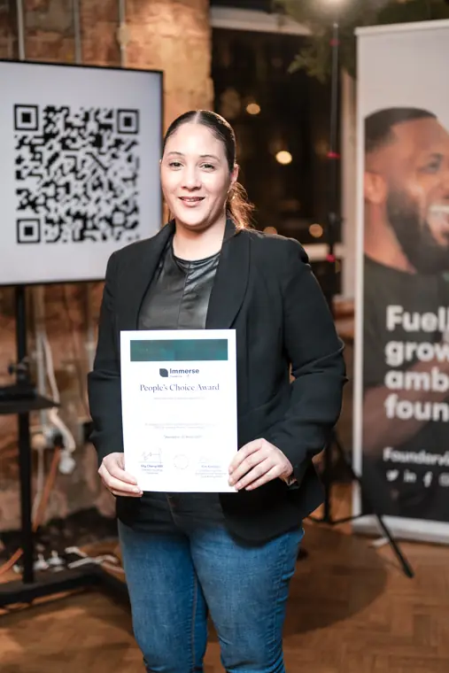A founder holds her recognition certificate.
