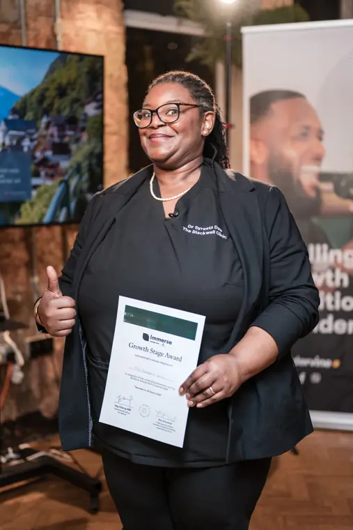 A founder pauses with her award.