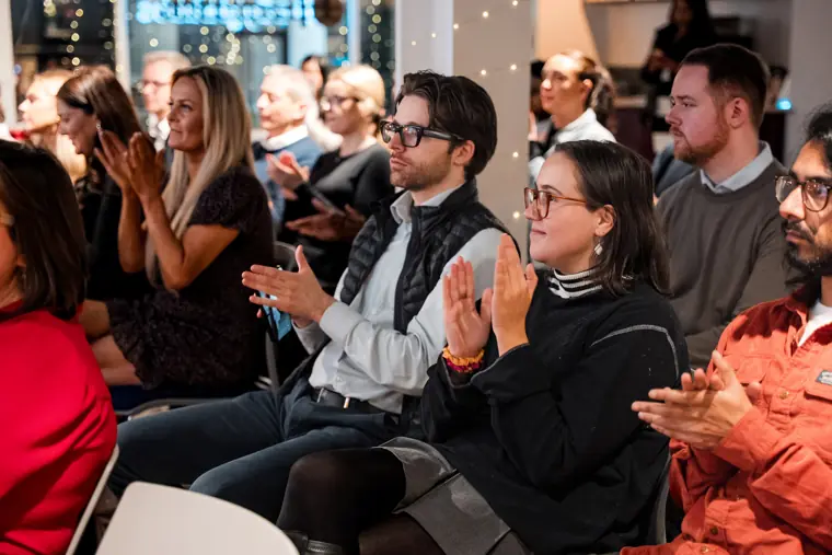 Audience members applaud a presentation.