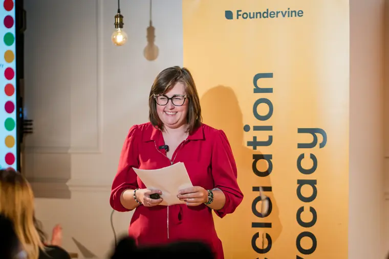 A speaker welcomes attendees to the event.