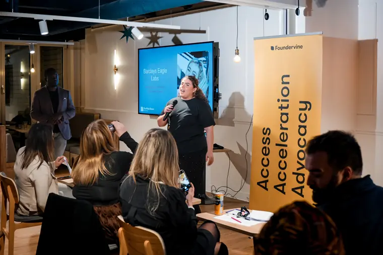 The audience watches a founder presentation.