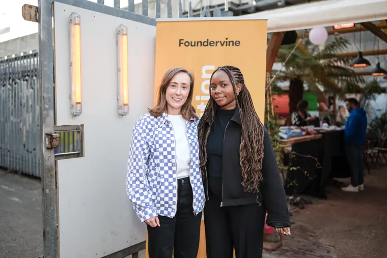Guests pose beside the Foundervine banner.