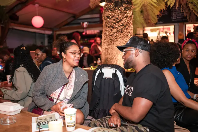 Attendees meet beneath the venue greenery.