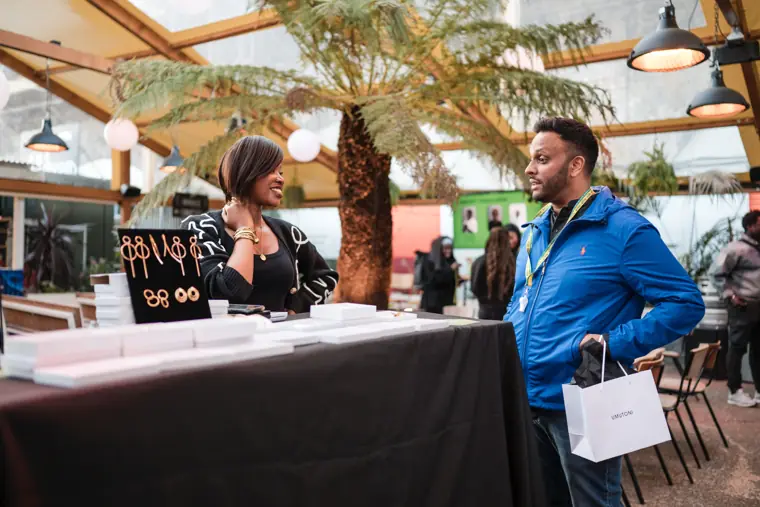 A visitor speaks with an exhibitor.