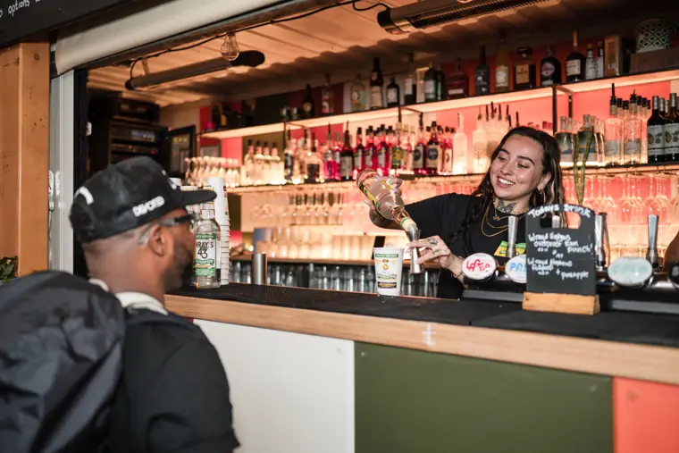 A guest speaks with a member of the bar team.