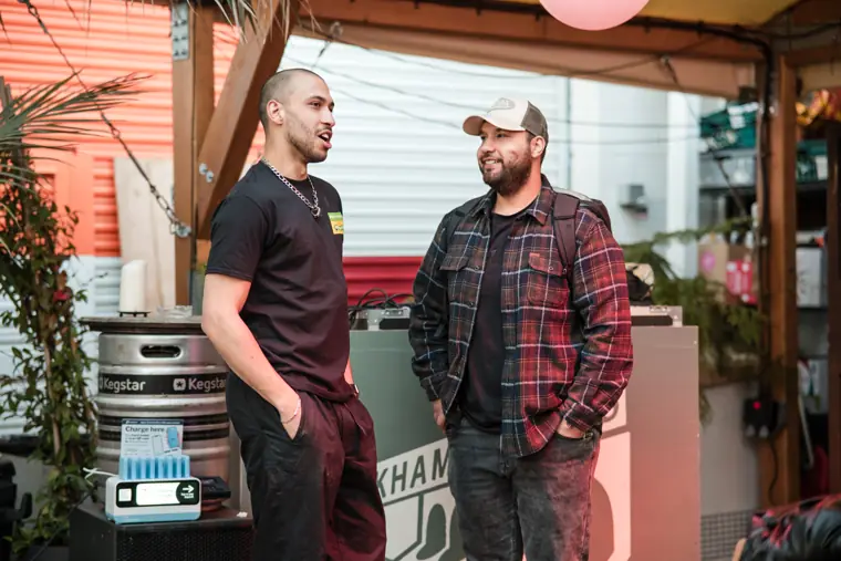 Two guests talk beside the venue entrance.