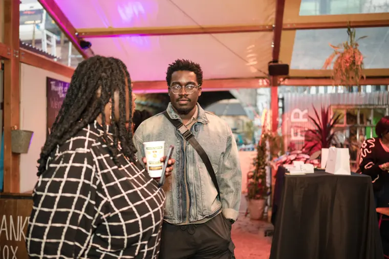 Two attendees catch up inside Peckham Arches.