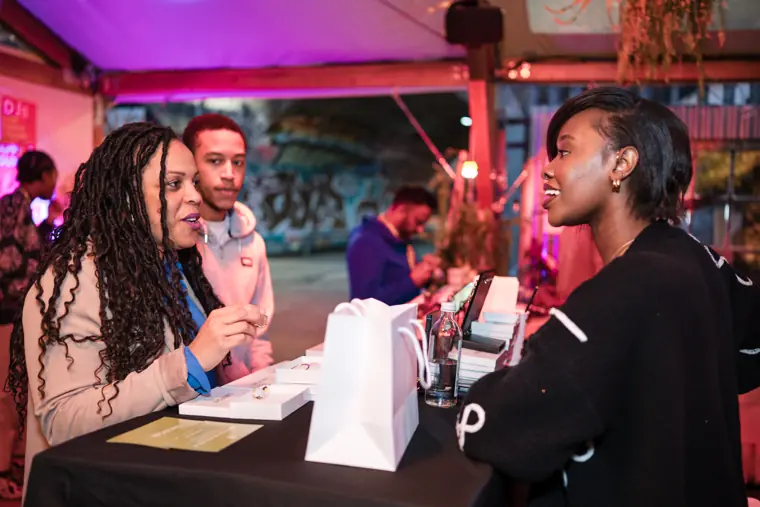 A founder talks with a visitor at her stand.