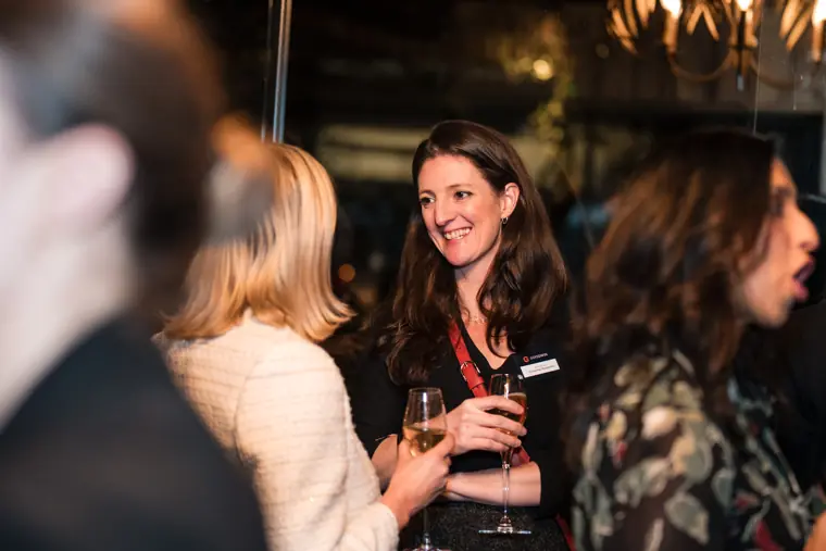 A guest smiles while speaking with another attendee.