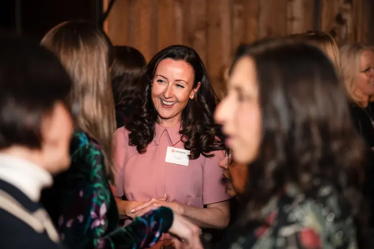 A guest joins a conversation with two attendees.