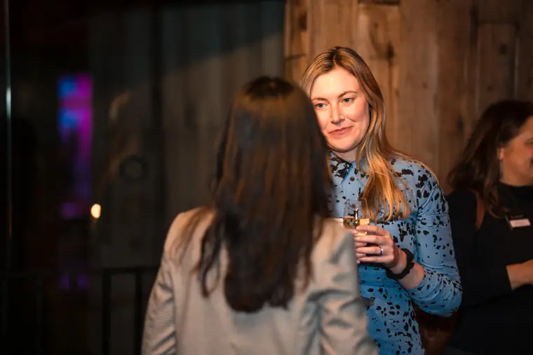 A guest smiles while holding a drink.