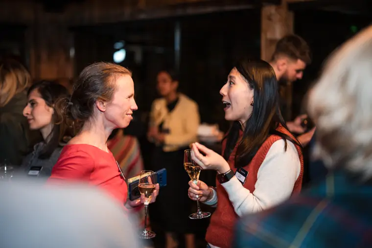 Two guests catch up over drinks.