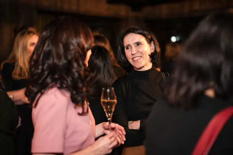 Two women smile while talking in the venue.