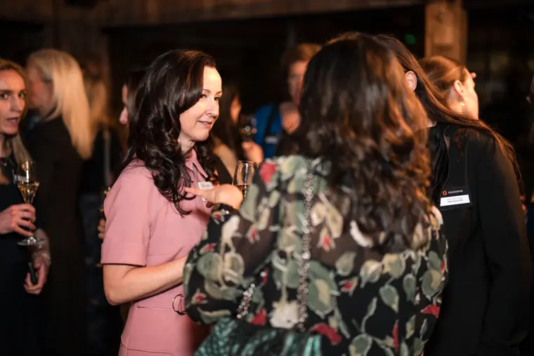 Two guests talk over wine at the reception.