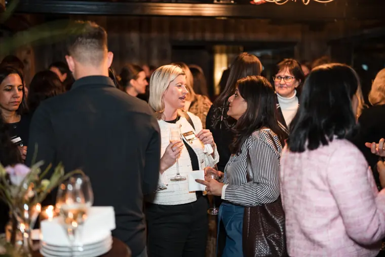 A guest smiles while holding a drink.
