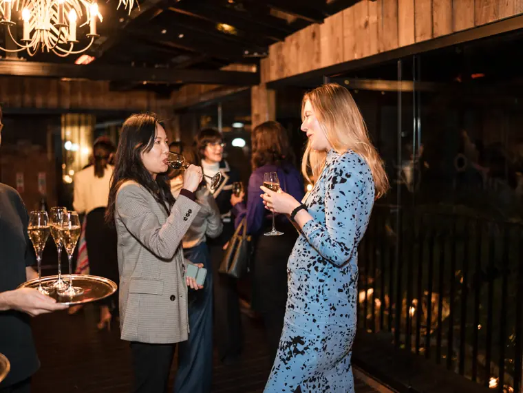 Two guests talk beneath the venue lights.