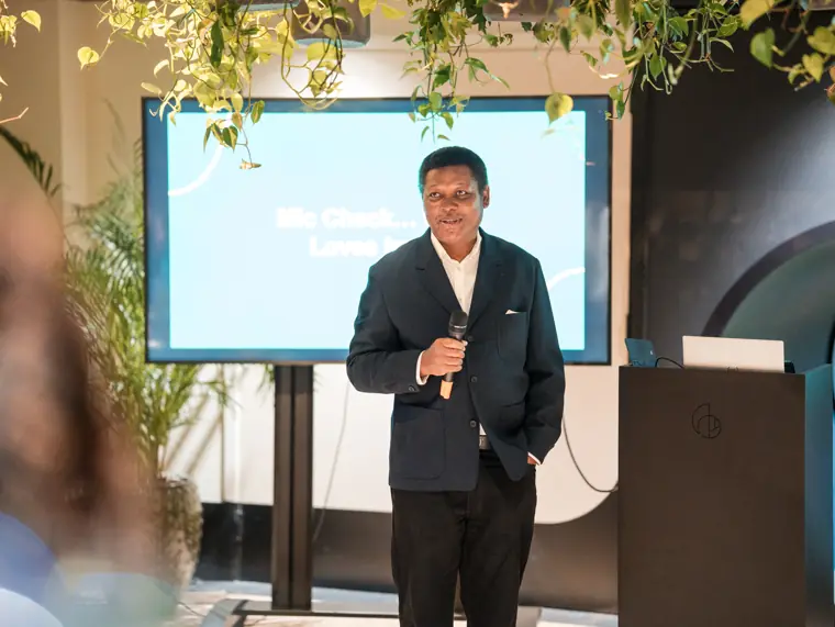 Guest speaking beside the celebration screen.