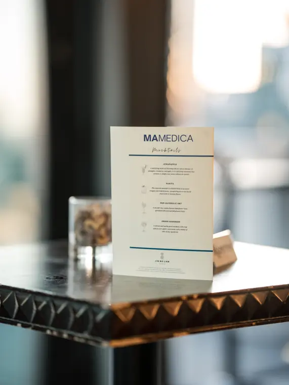 MaMedica event card displayed beside the drinks.