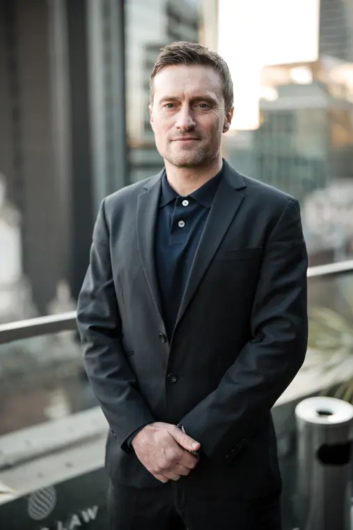 Portrait of a team member in a dark jacket outside the venue.