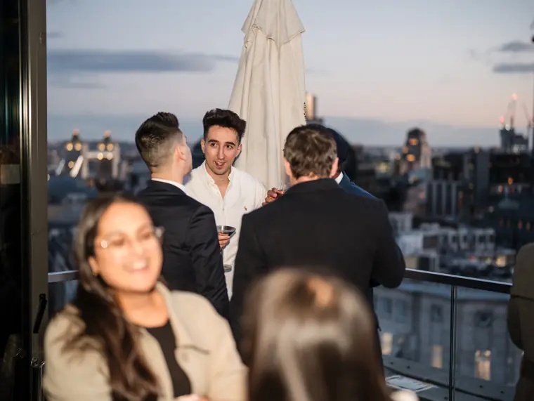 Guests meeting on the rooftop terrace at dusk.
