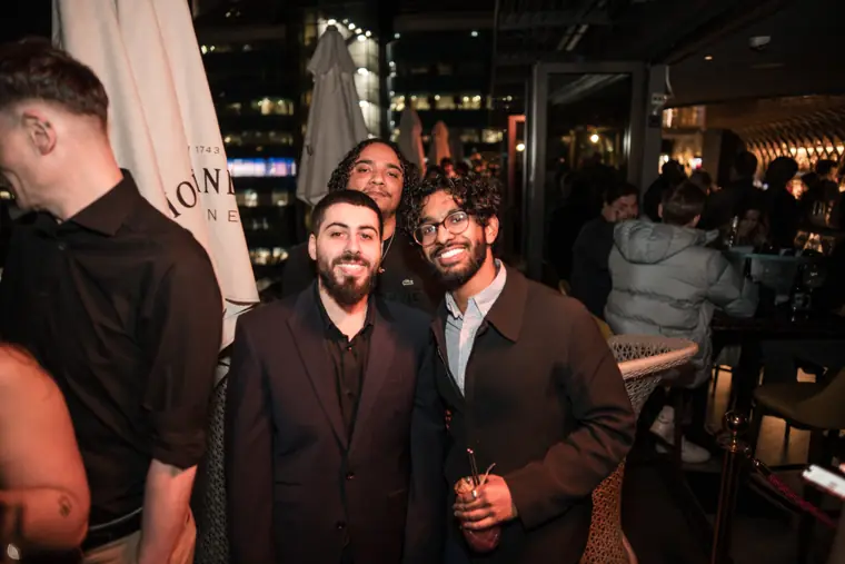 Three men posing together during the evening reception.