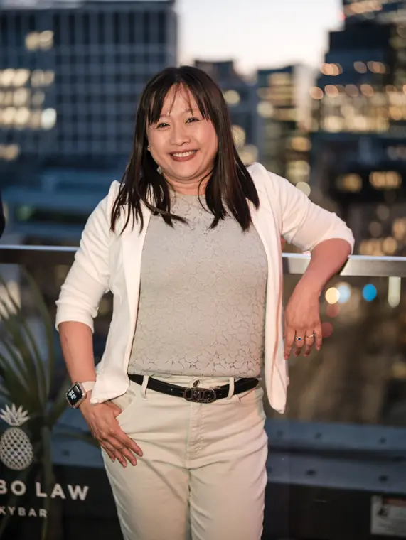 Portrait of a woman in a white blouse on the rooftop.