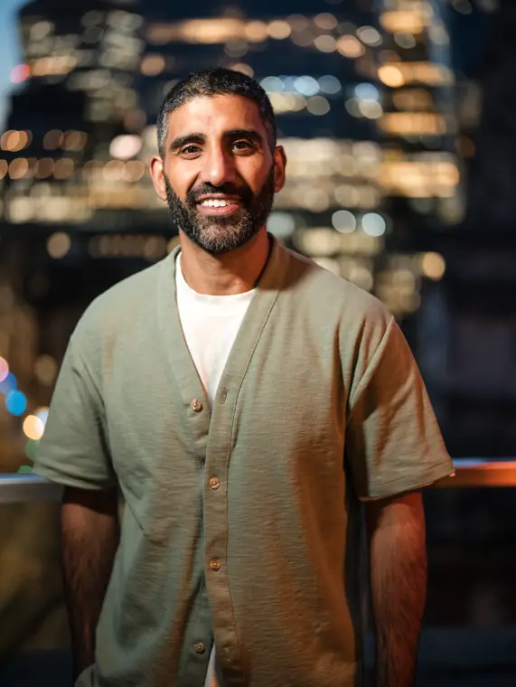 Portrait of a guest with the city lights behind him.