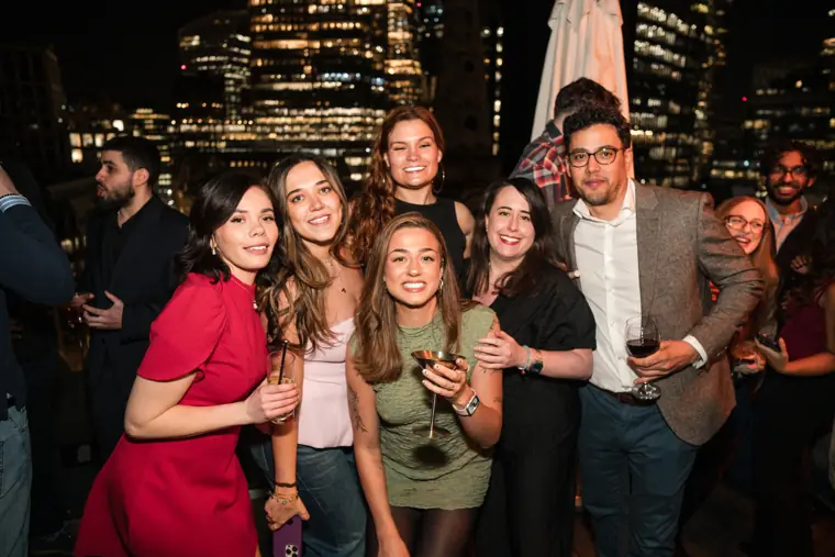 A group of guests posing together at night.