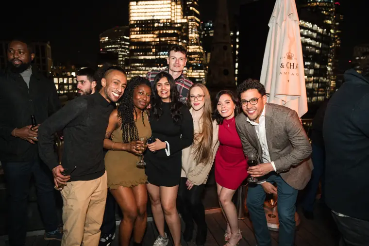 Large team group posing against the city skyline.