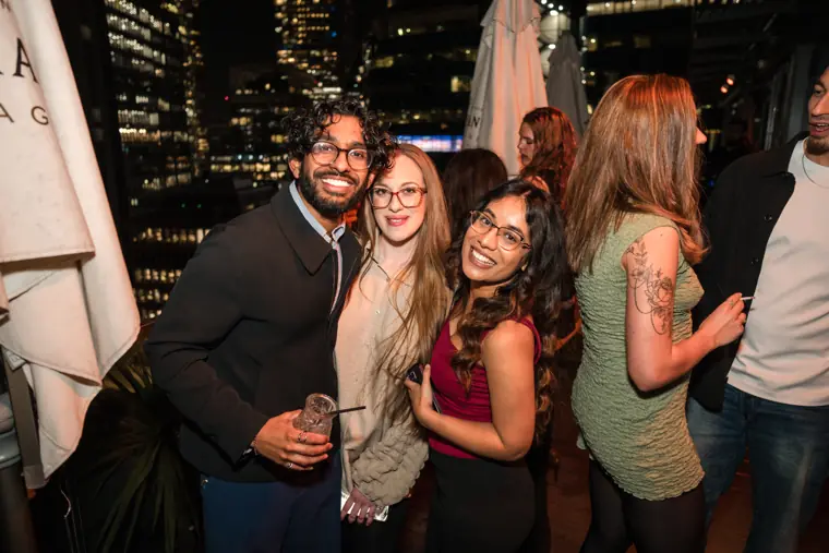 Friends and colleagues smiling together on the rooftop.
