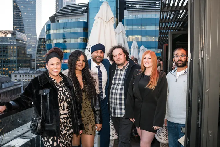 Team members posing together on the terrace in daylight.
